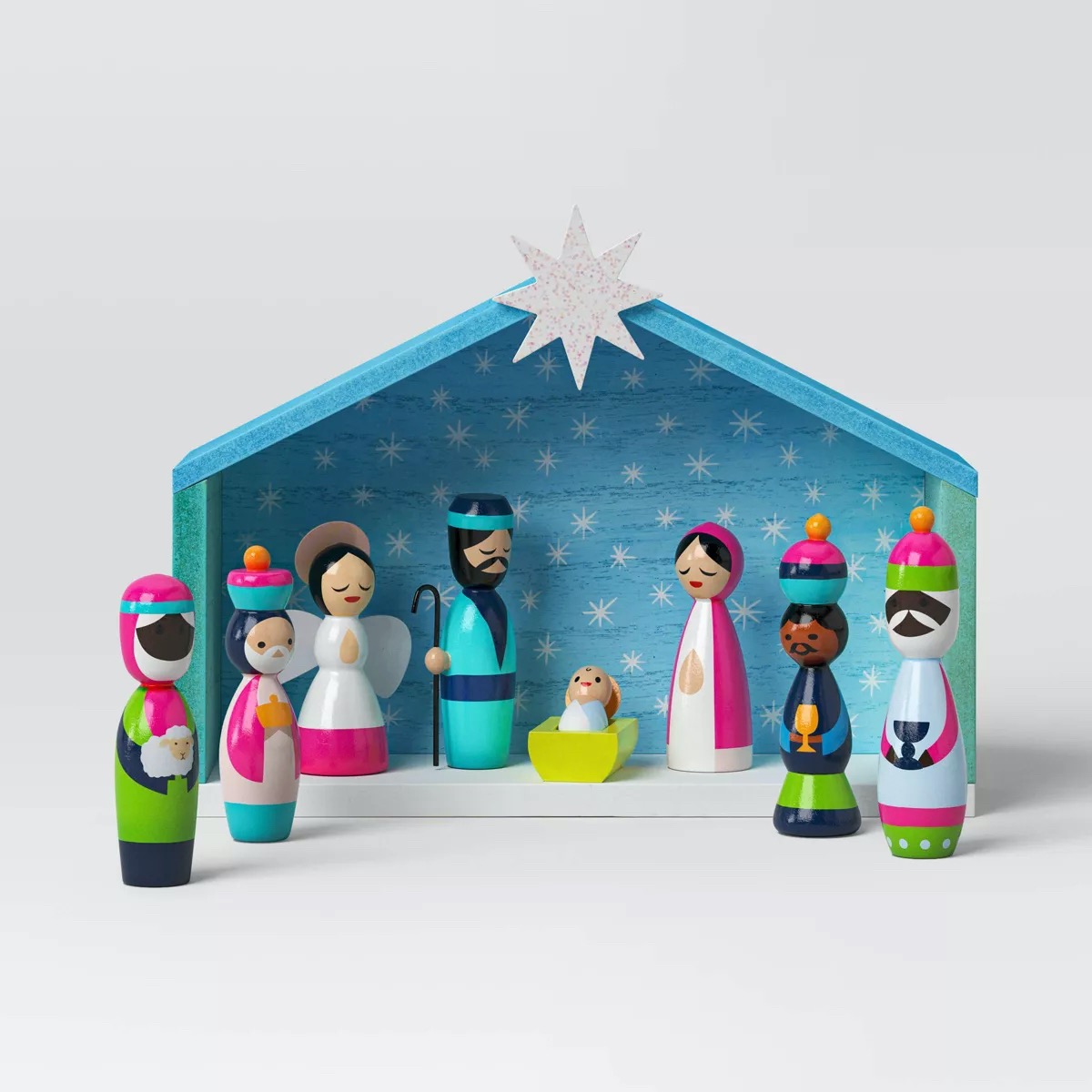 A small, colorful nativity scene from Target, a yellow star above a turquoise créche