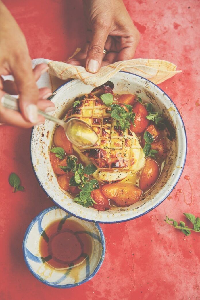 Whole grilled halloumi with apricots A bowl of grilled halloumi with apricots on a red background