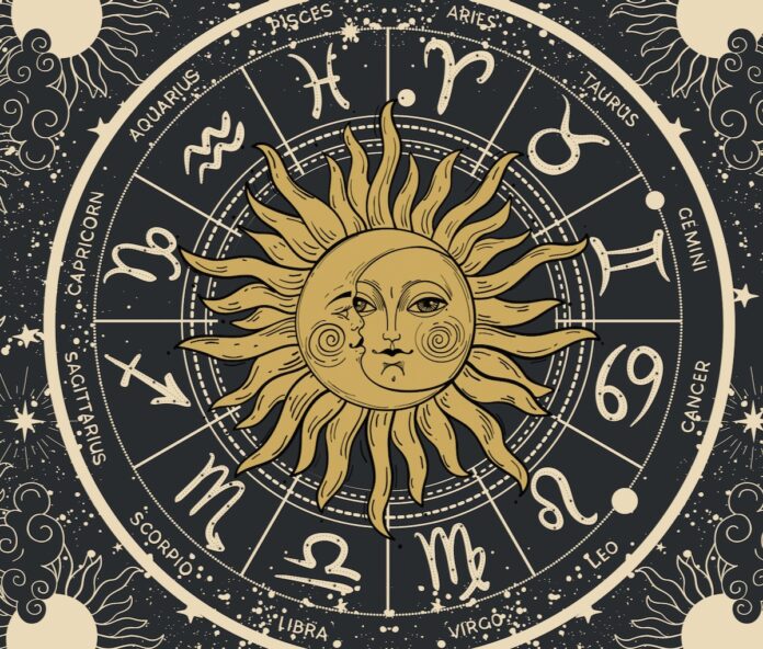 An illustration of a sun and moon in the center of a zodiac horoscope wheel in the colors of yellow and grey to represent the winter.