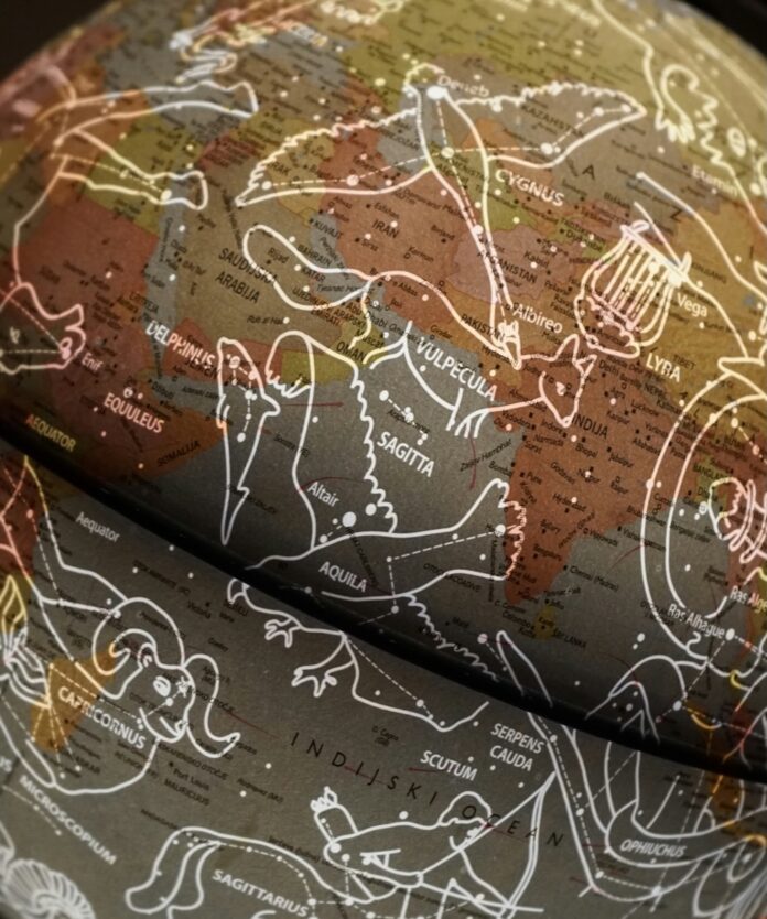 Your Full Moon Horoscope: December 2024 A globe with the constellations laid overtop in a white color.