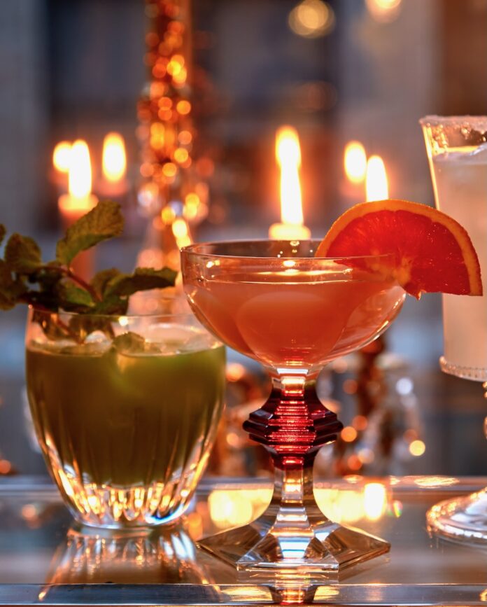 Tequila Cocktails Maribel Lieberman Two tequila cocktails, one red and one green, sit beside each other on a candlelit table