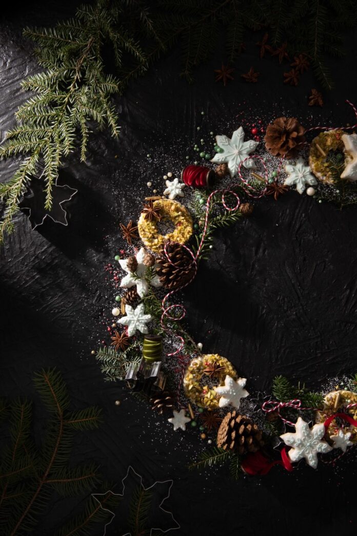 A wreath made out of Christmas cookies, powdered sugar, and greenery.
