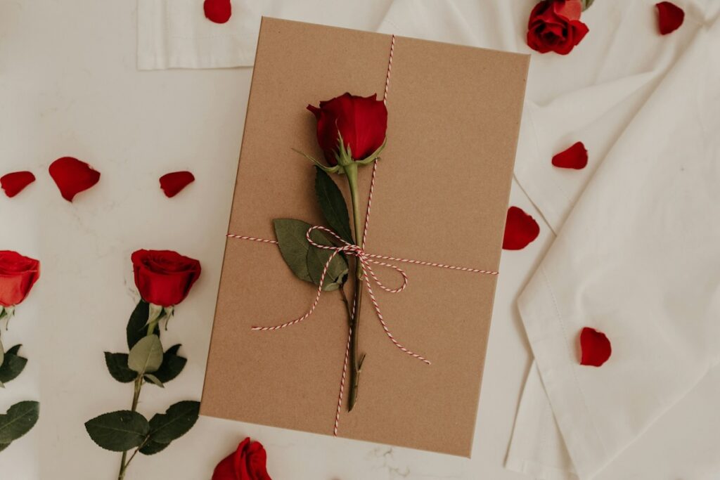 A rose on top of a light brown card for Valentine's Day