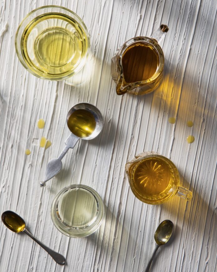 A set of small containers of olive oil, displaying their different colors and qualities from above.