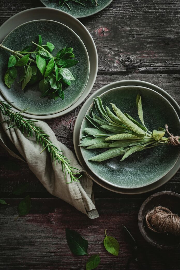 Uses for Herbs Two plates of bright green herbs on a rustic, dark wood table