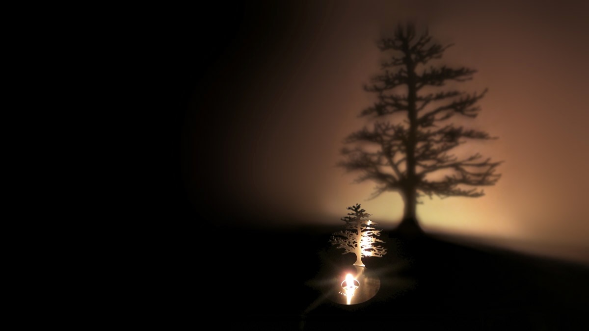 An oil lamp from Adam Frank, staged with a projection of a tree in a dark room