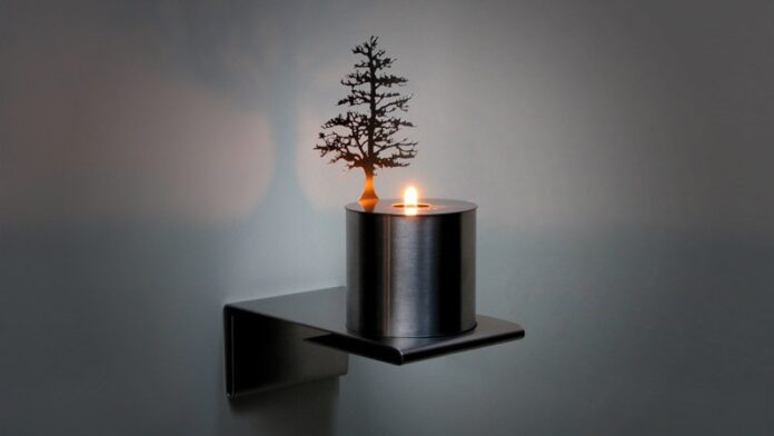 An oil lamp from Adam Frank projecting a tree onto a silver wall