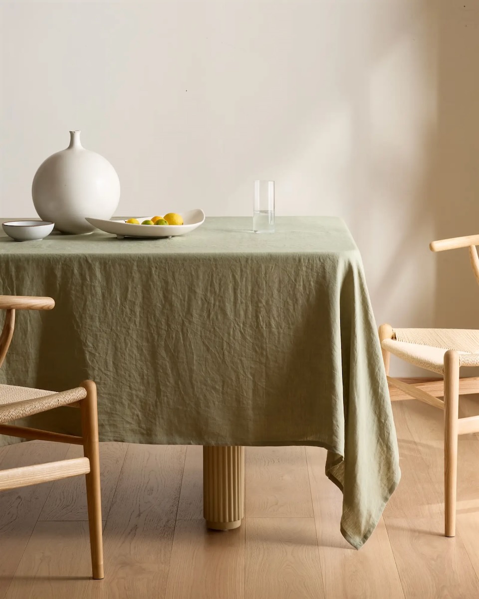 A pale green tablecloth by Quince staged in an inviting dining room 
