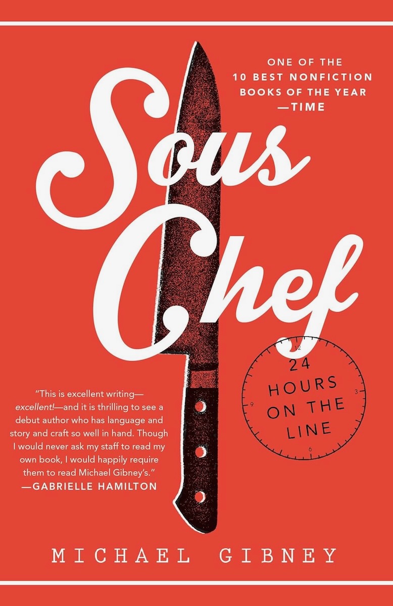 The cover of Sous Chef by Michael Gibney, a red graphic with a knife in the middle bisecting the book's title in a cursive font. 