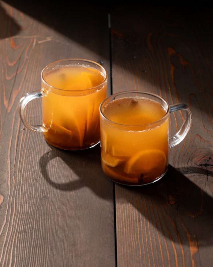 Two cups of boilo on a wooden background.
