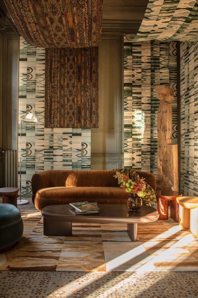 An interior by Pierre Frey with a large couch in the middle of it.