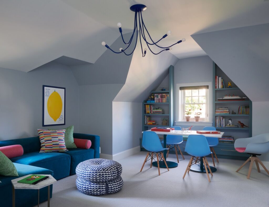 Another child's room has blue walls along with a blue couch to the left wall and blue chairs around a table near the back wall.
