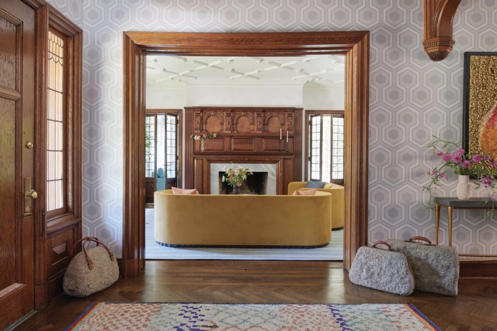 The living room with a yellow couch can be seen through the dark brown wood trim doorway.