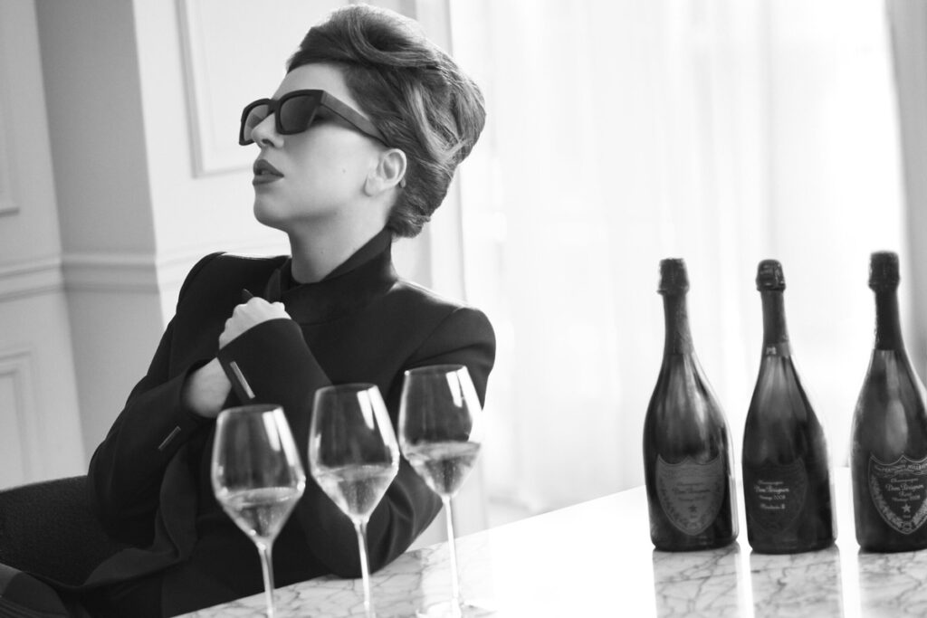 Lady Gaga sits beside several glasses of wine in a photoshoot for Dom Perignon.