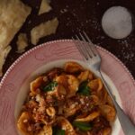 A plate of handmade orecchiette pasta with a meat sauce.