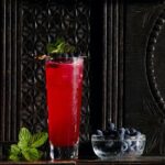 A glass of Market Alley Gin Punch on a black backgroound.
