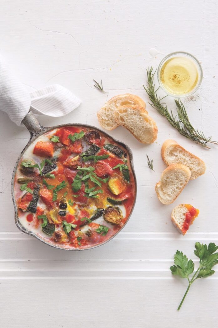 A plate of North African shakshouka staged with crusty bread.