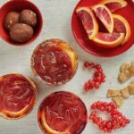 An apple cider negroni surrounded by orange peels and other delicious ingredients.