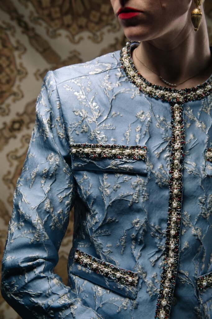 A woman in a blue button up top in spring blue colors.
