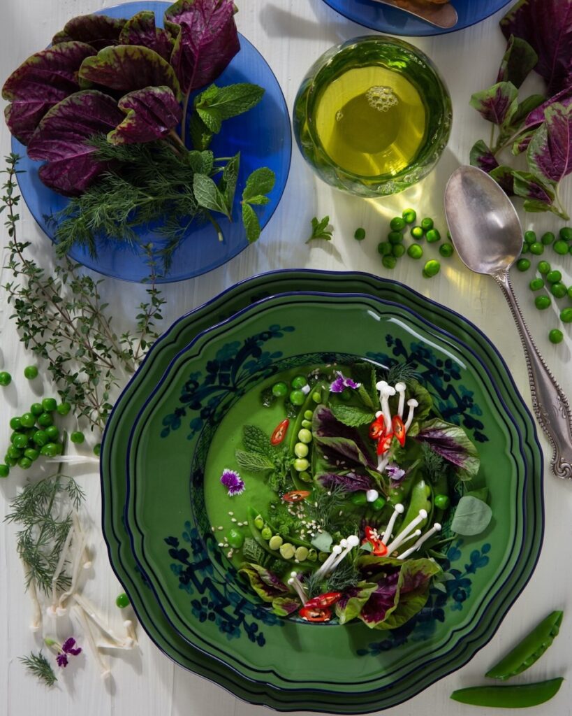 Pea soup on a green plate on a white background.