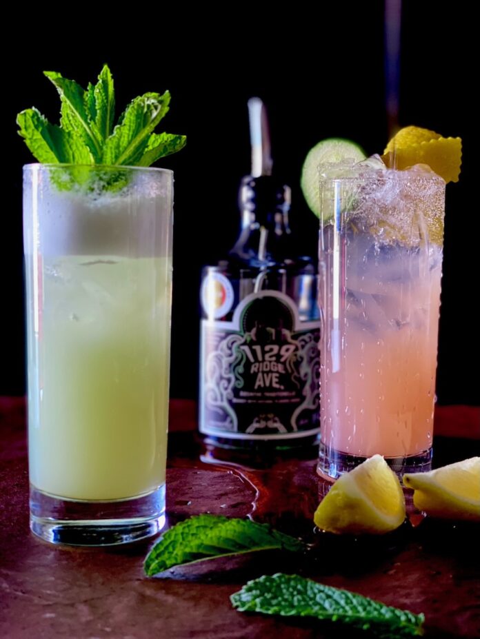 A pink and purple gin spritz with a cucumber wheel in it.