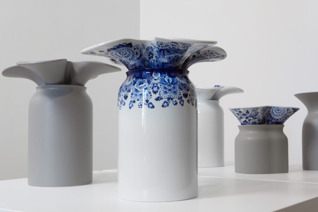 A blue and white milk can that's flattened out on top and curved a bit.