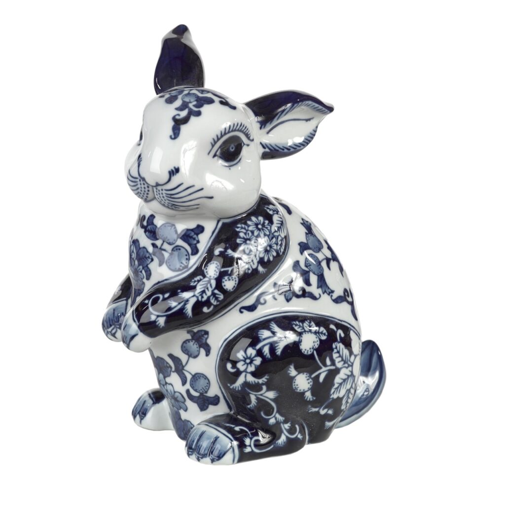 A small blue and white porcelain bunny sits on a white background.