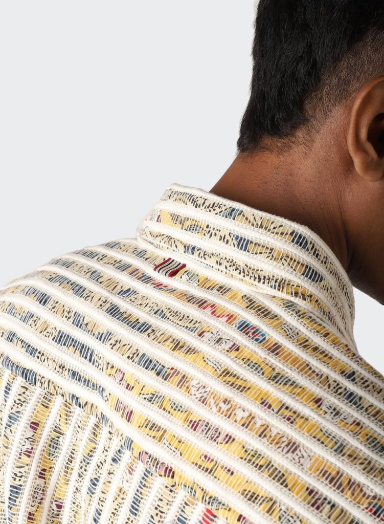 A man wears a striped shirt with various colors throughout.
