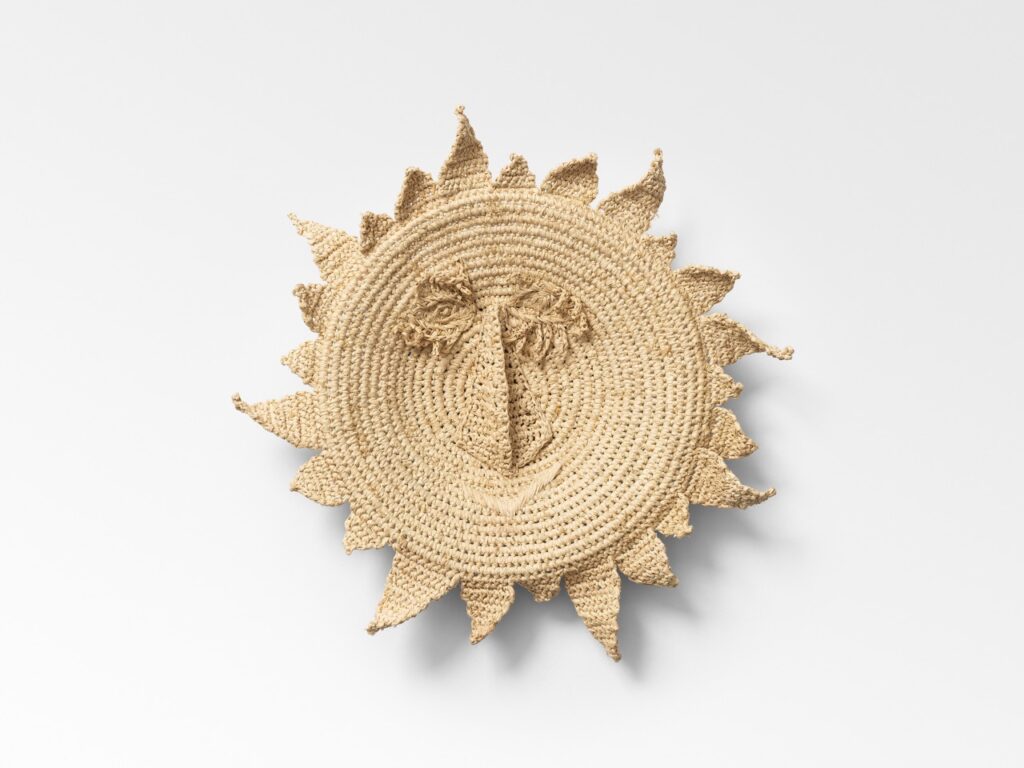 A surrealism cream colored wove sun decor piece.