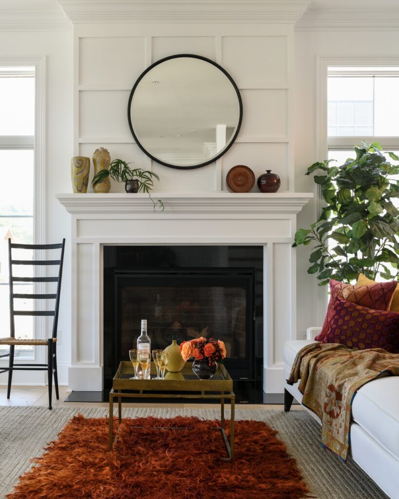 New residential construction in Pittsburgh with a living room that has white walls, a red rug, and a white mantel fireplace.