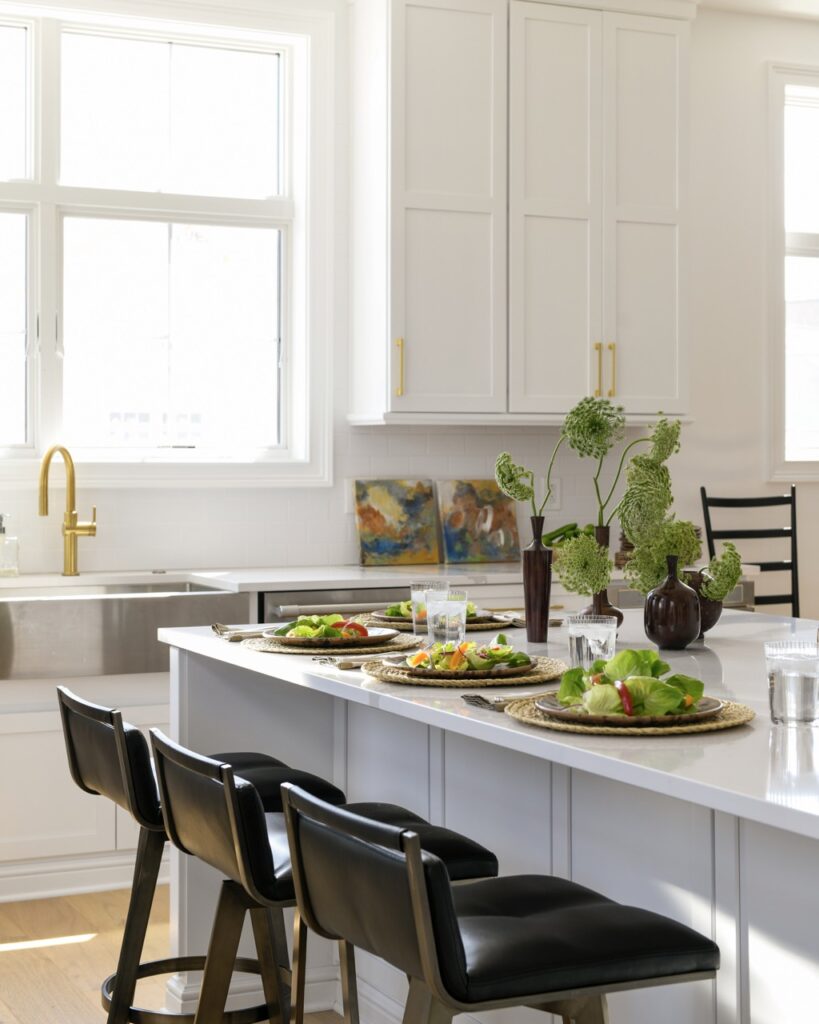 A dining room area of a new construction Pittsburgh home with a white countertop, black chairs, and a gold faucet sink.