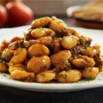 On a white plate sits a mound of GIANT BEANS WITH HONEY AND DILL.