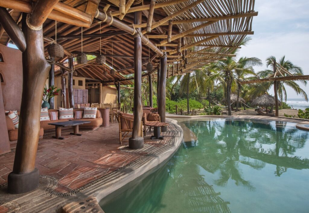 The outside of a pool with a circular lounge in the center at Playa Viva.