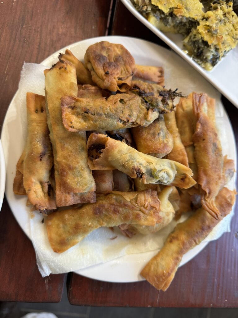 An aerial shot of a white plate piled with SMALL CHEESE AND PHYLLO PIES.
