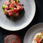 An above shot of a plate of a brightly color serving of Tuna Poke on a white speckled plate.