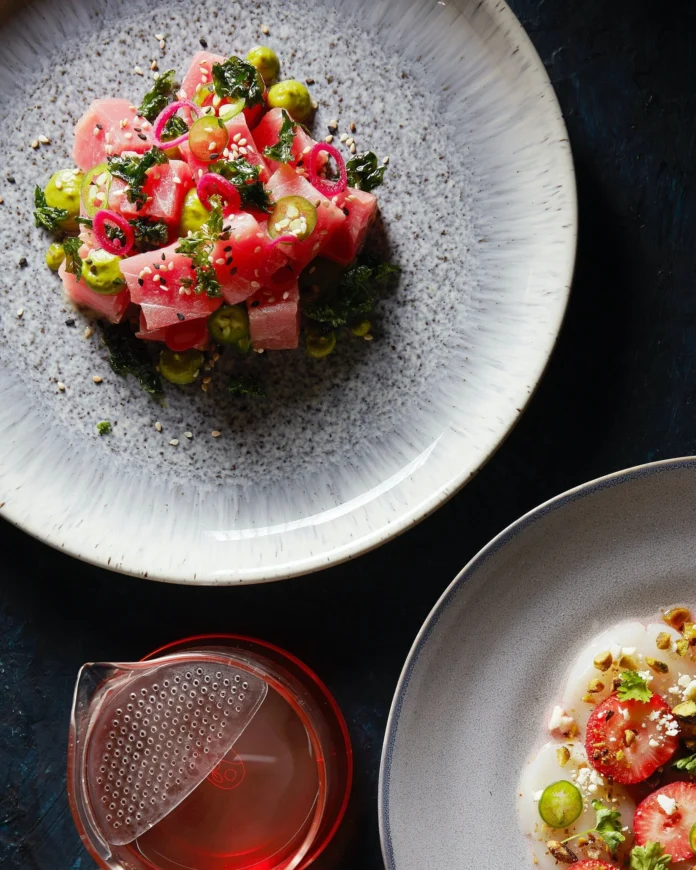 An above shot of a plate of a brightly color serving of Tuna Poke on a white speckled plate.