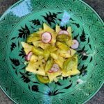 Zebra Tomato and Yellow Watermelon Salad on turquoise plate with black design.