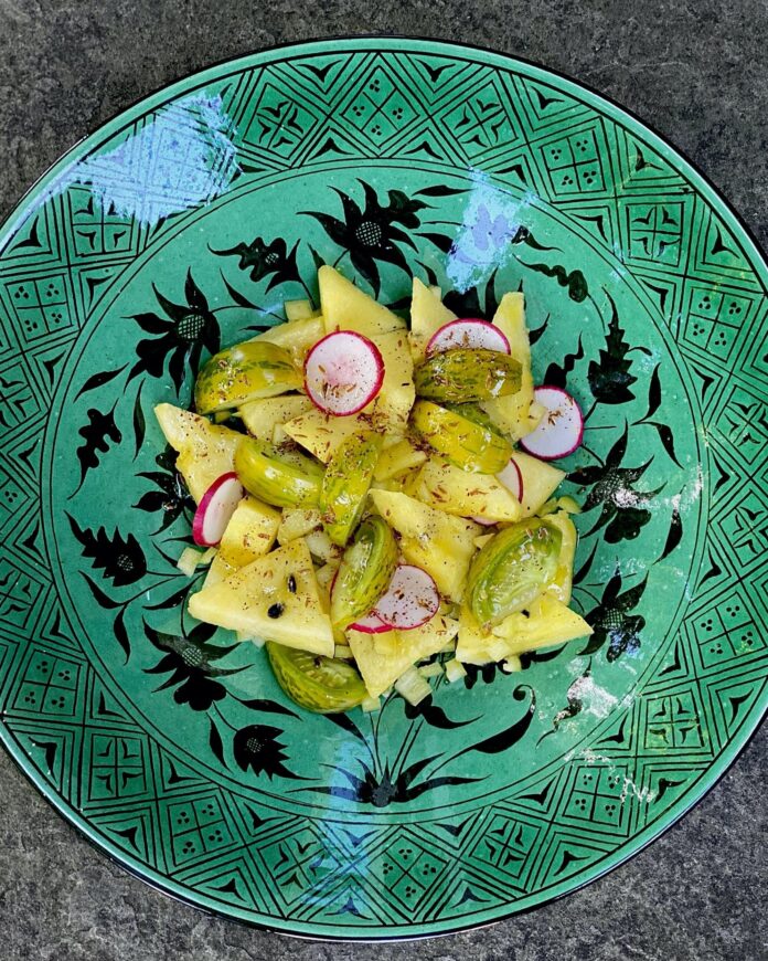 Zebra Tomato and Yellow Watermelon Salad on turquoise plate with black design.