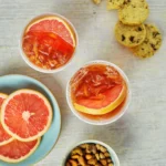An above shot of two glasses filled with an orange liquid, Bourbon Paloma.