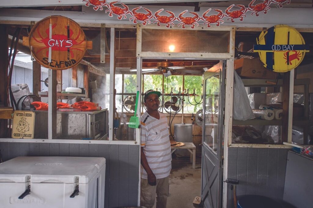 A person stands in the doorway of a seafood restaurant.