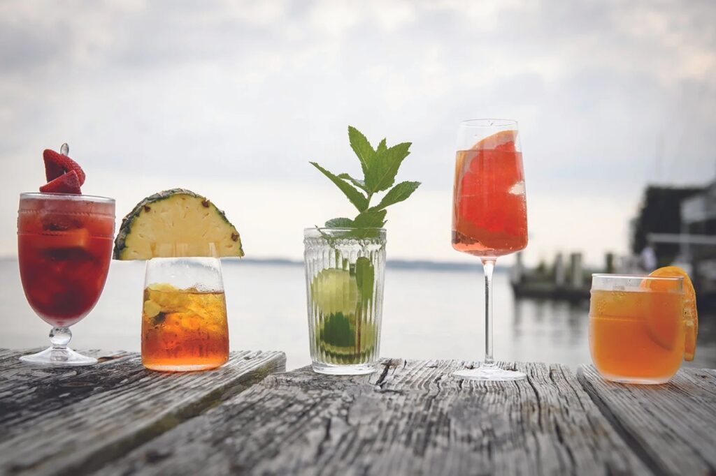 A dock of various fruit cocktails with extravagant garnishes.