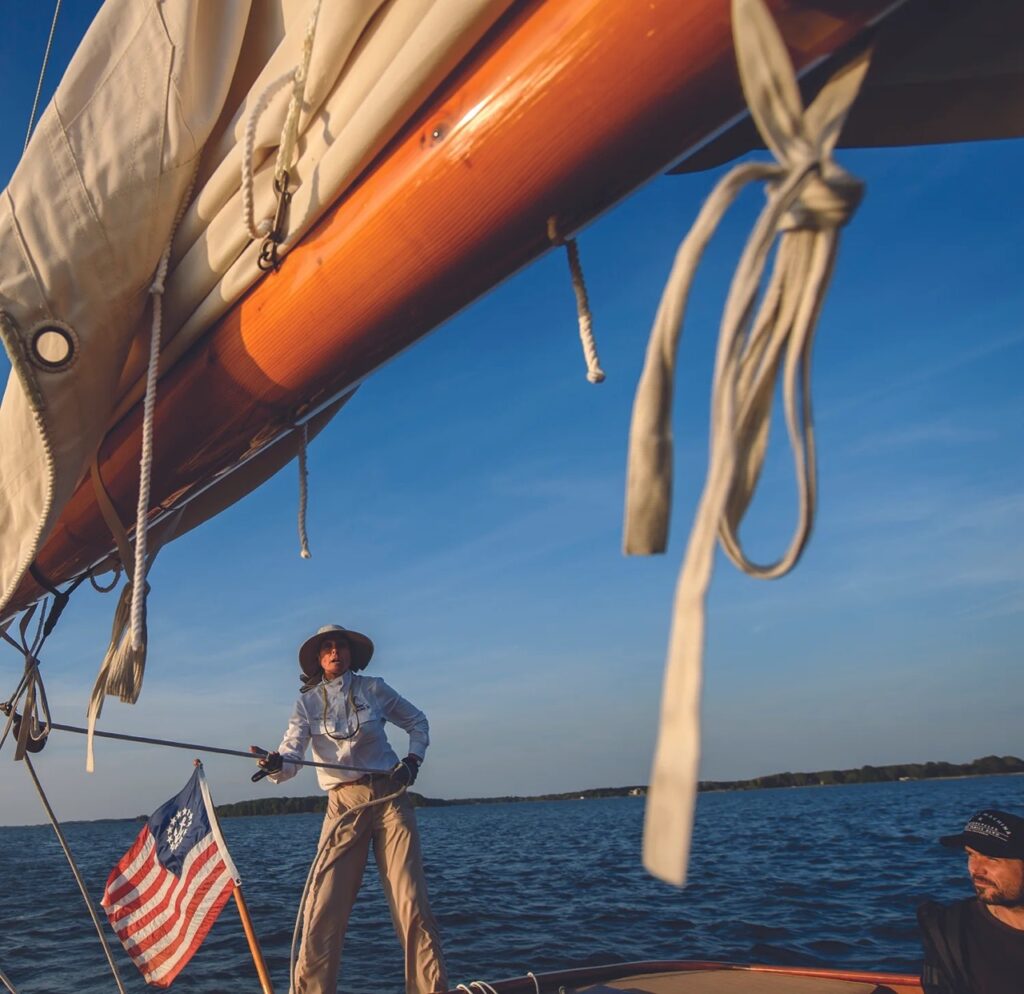 A captain stands on their boat in the ocean.