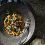 An aerial shot of a gray stone bowl filled with GNOCCHI WITH BRAISED OXTAIL AND COLLARD GREENS.