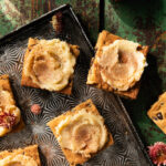 Dark Rum Blondies with butter spread on a serving plate with wild flowers scattered around.