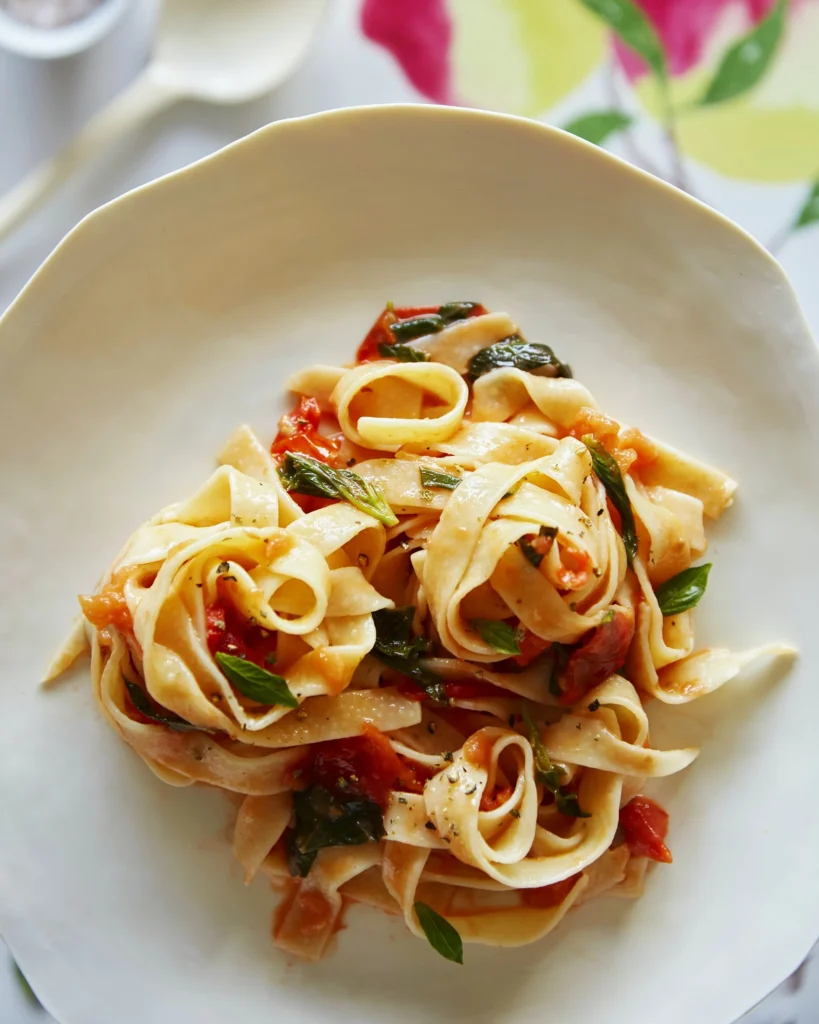 An above shot of a white plate that holds pasta, Heirloom Tomato Tripoline