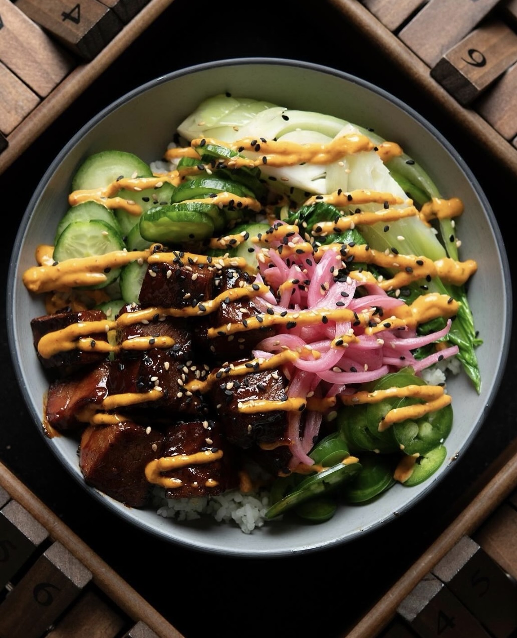 capitol coal food bowl with greens and spicy sauce drizzled