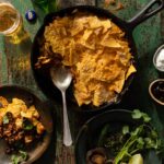 A skillet full of Taco Casserole with cheese, nacho chips, and taco meat.