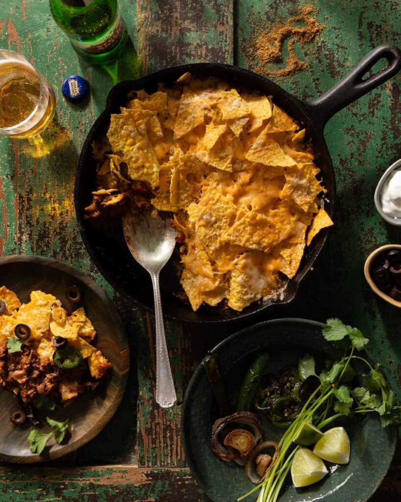 A skillet full of Taco Casserole with cheese, nacho chips, and taco meat.