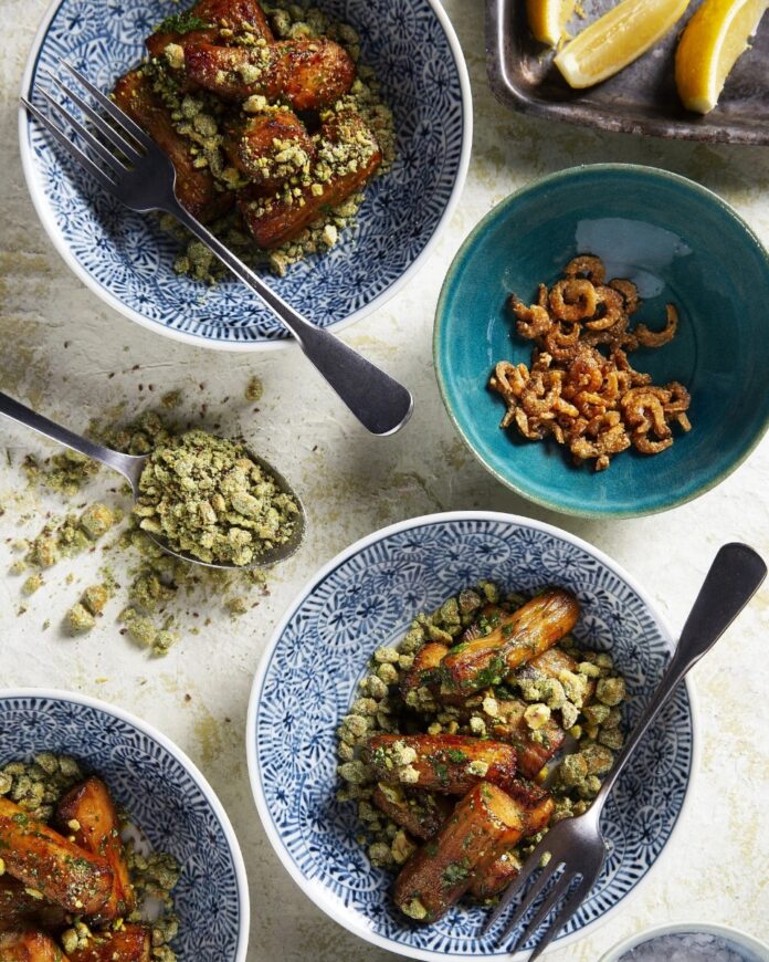 Blue-and-white patterned bowls filled with roasted eggplant, topped with a green crumble, with a separate bowl of dried anchovies.
