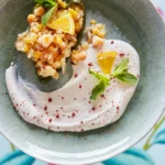 An above shot of a sea-green, light blue bowl filled with Seafood Stuffed Poblano Peppers.